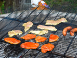 Schweine und Putenfleisch, sowie Rote Würste bruzzeln am Grill