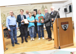 Bürgermeister Davide Licht überreicht eine Gratulations-Urkunde und ein kleines Präsent